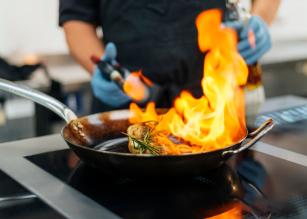 chef-with-gloves-flambeing-dish